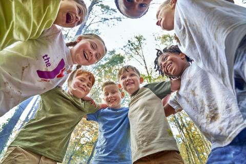 children in huddle outdoors activity smiling