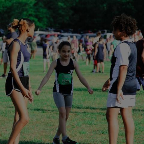 Three runners on track team in action