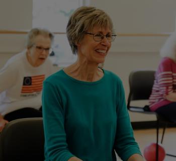 seniors_class.jpg Woman smiles during group exercise class